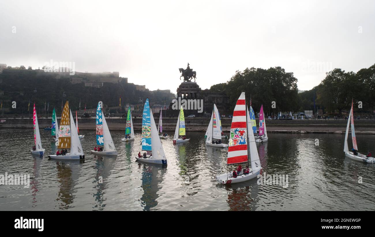 Coblenza, Germania. 25 Settembre 2021. Il campo di partenza della regata culturale di vela 'Mailing #Art4GlobalGoals', una mostra d'arte vela sull'acqua lascia la bocca della Mosella a Deurschen Eck a Coblenza (vista aerea con un drone). Le 17 opere di vela iniziano sulle rive della Mosella a Coblenza per poi trasportare il colorato messaggio degli obiettivi di sviluppo sostenibile del 17 in un viaggio di 120 chilometri che li porta via Sinzig, l'afflusso dell'Ahr nel Reno e Bonn, con una sosta a Colonia, Ritorno a Monheim am Rhein. Credit: Thomas Frey/dpa/Alamy Live News Foto Stock