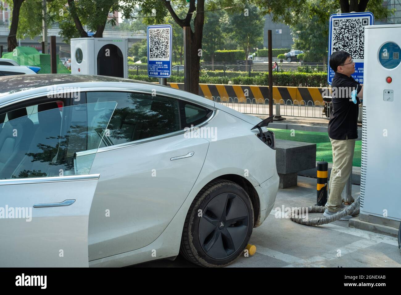 L'uomo cinese lavora con una macchina di ricarica auto in una stazione di Pechino, Cina. 25 settembre 2021 Foto Stock