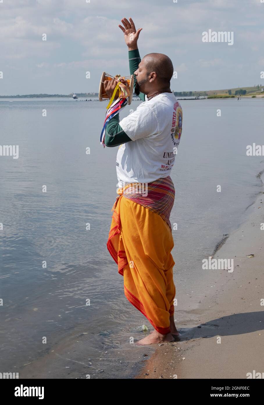 Un devoto adoratore indù prega ai margini della Giamaica Bay ad un servizio di Ganga e Kateri Amma Poosai. A Queens, New York. Foto Stock