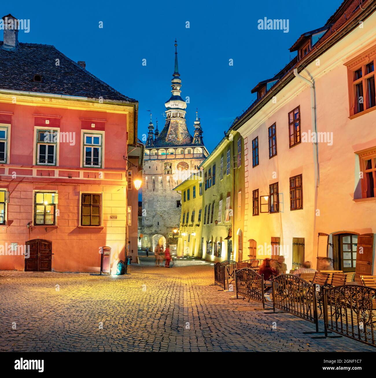 Pittoresca vista serale della famosa città fortificata medievale e della Torre dell'Orologio costruita dai Sassoni. Paesaggio urbano estivo illuminato di Sighisoara, Transilva Foto Stock