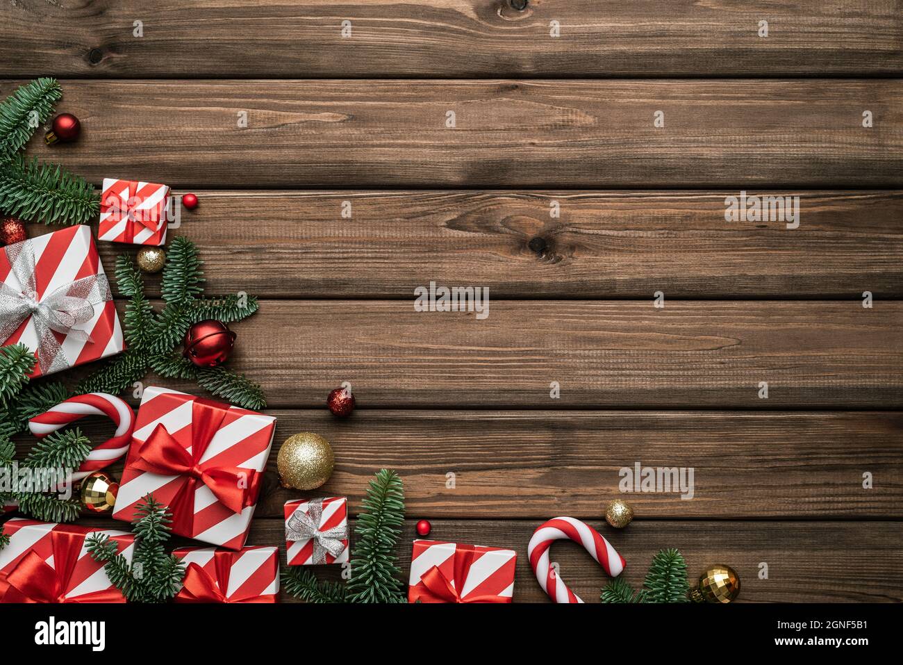 Sfondo natalizio festivo con scatole di regali, campane di slitta e rami decorati di abete Foto Stock