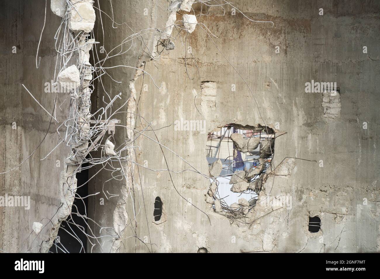 Una struttura in cemento armato parzialmente rovinato, con barre di rinforzo in acciaio storte che sporgono dalle pareti. Foto Stock