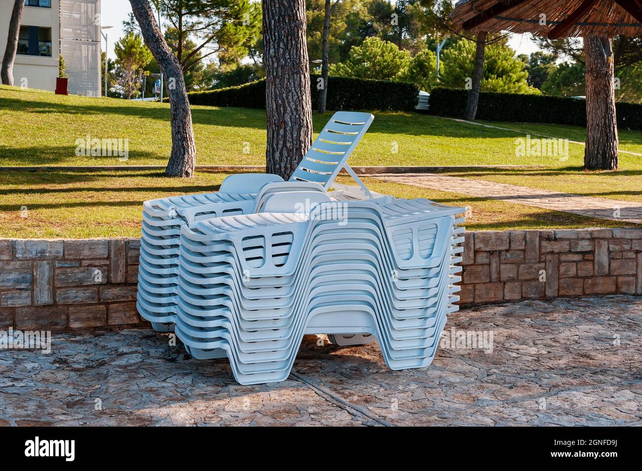 sulla spiaggia troverete una pila di lettini. Sul terrapieno ci sono sdraio pulite la sera Foto Stock