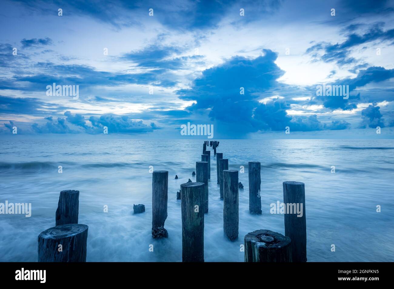 Scendi sopra i vecchi pilings del molo lungo il Golfo del Messico a Napoli, Florida, USA Foto Stock