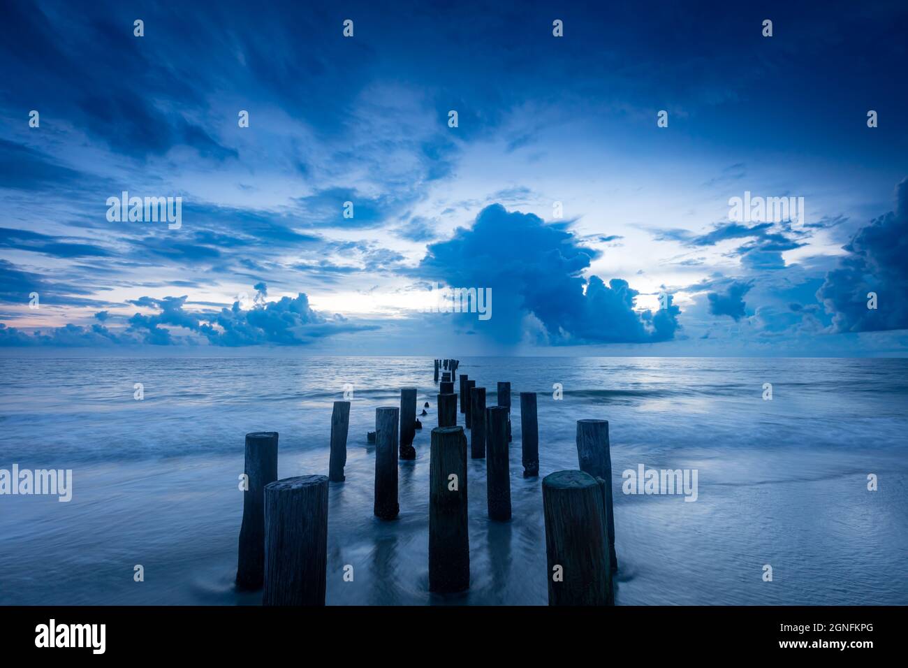 Scendi sopra i vecchi pilings del molo lungo il Golfo del Messico a Napoli, Florida, USA Foto Stock