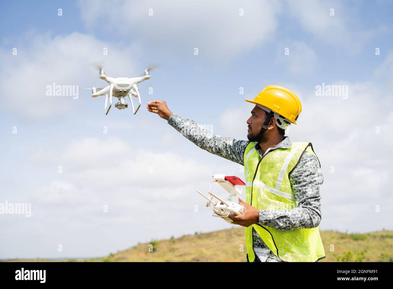 Drone Pilot riceve il drone in modo sicuro utilizzando il telecomando - concetto di ritorno a casa, indagine aerea utilizzando la tecnologia UAV Foto Stock