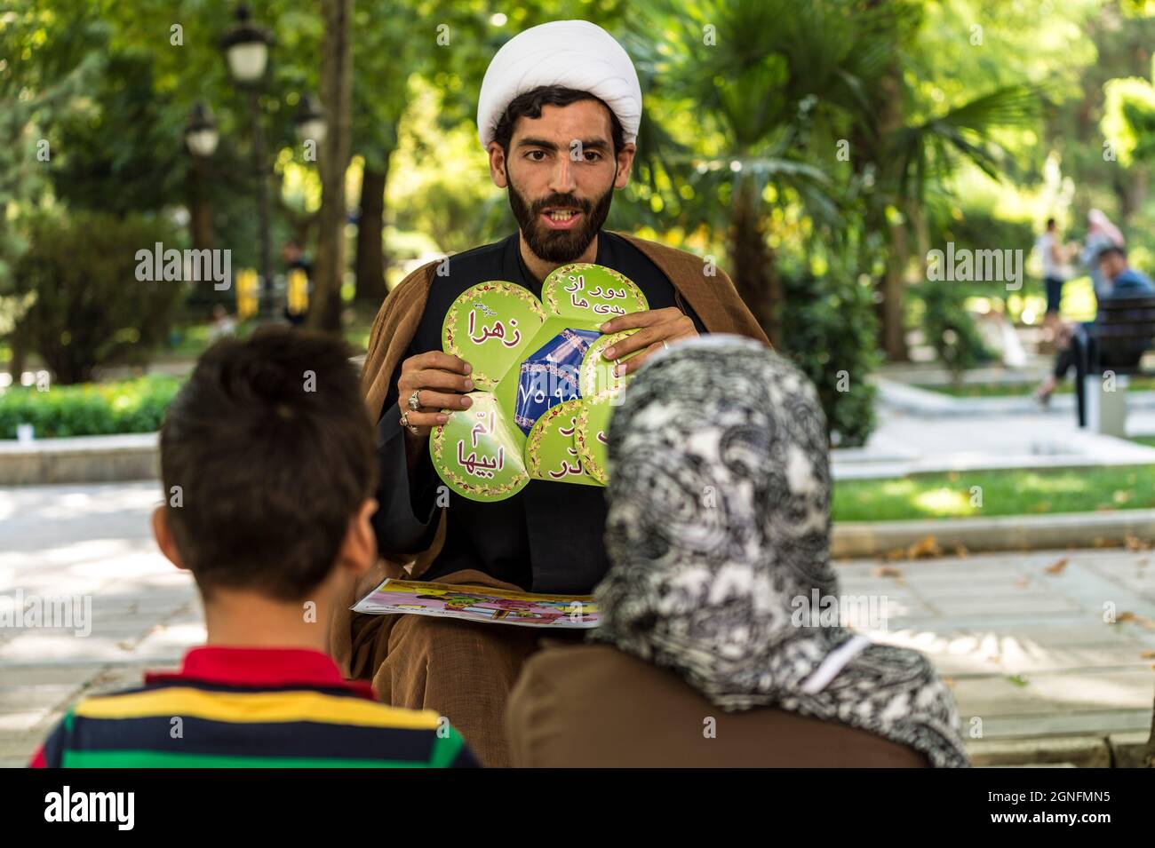 IRAN. TEHERAN. PARK-E SHAHR PARK AN IMAM STA INSEGNANDO FONDAMENTALE DELL'ISLAM AI BAMBINI Foto Stock