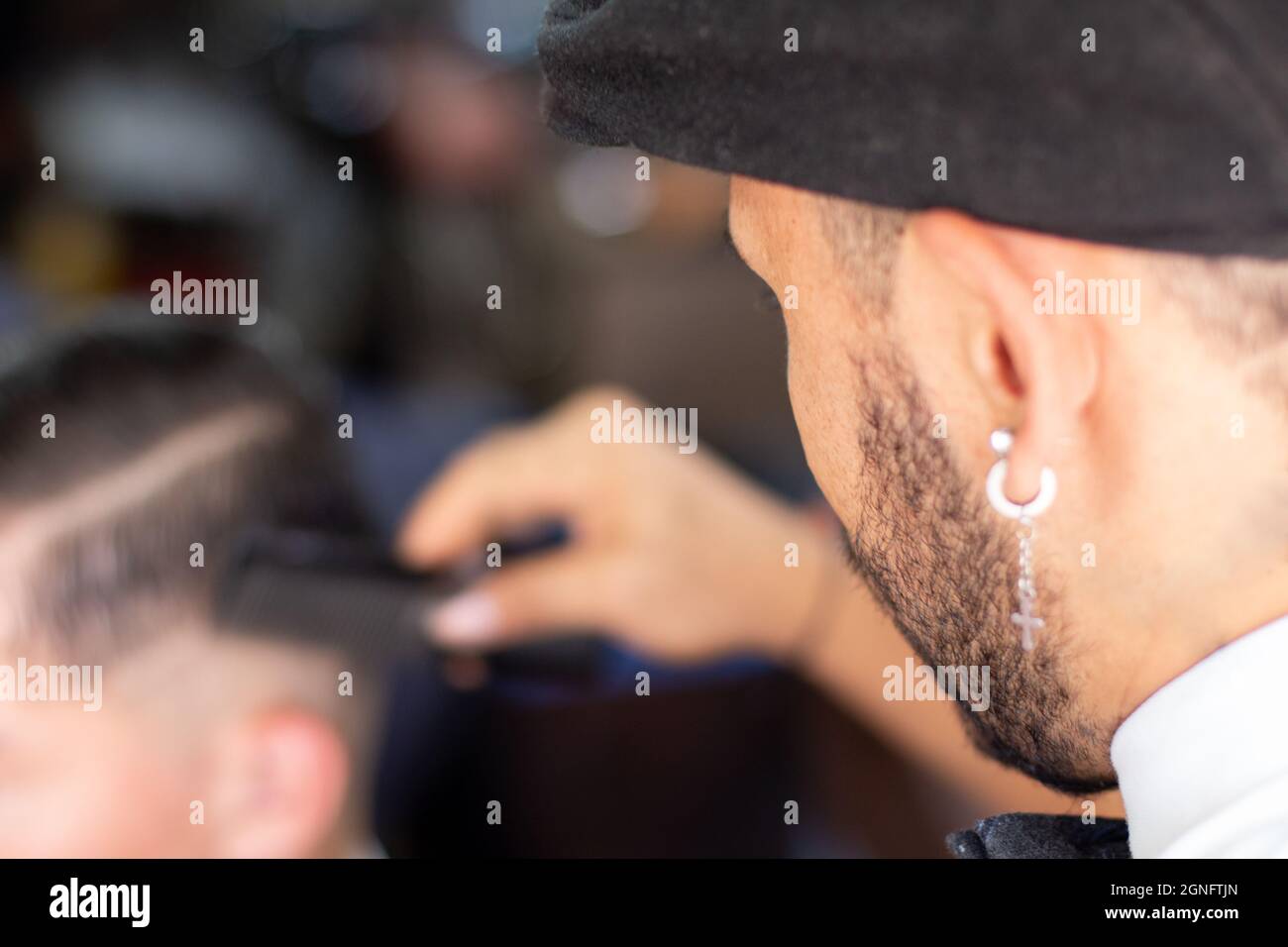 Uomo sconosciuto che pettina i capelli del suo cliente in un barbiere. Crescita di stimolazione dei capelli Foto Stock