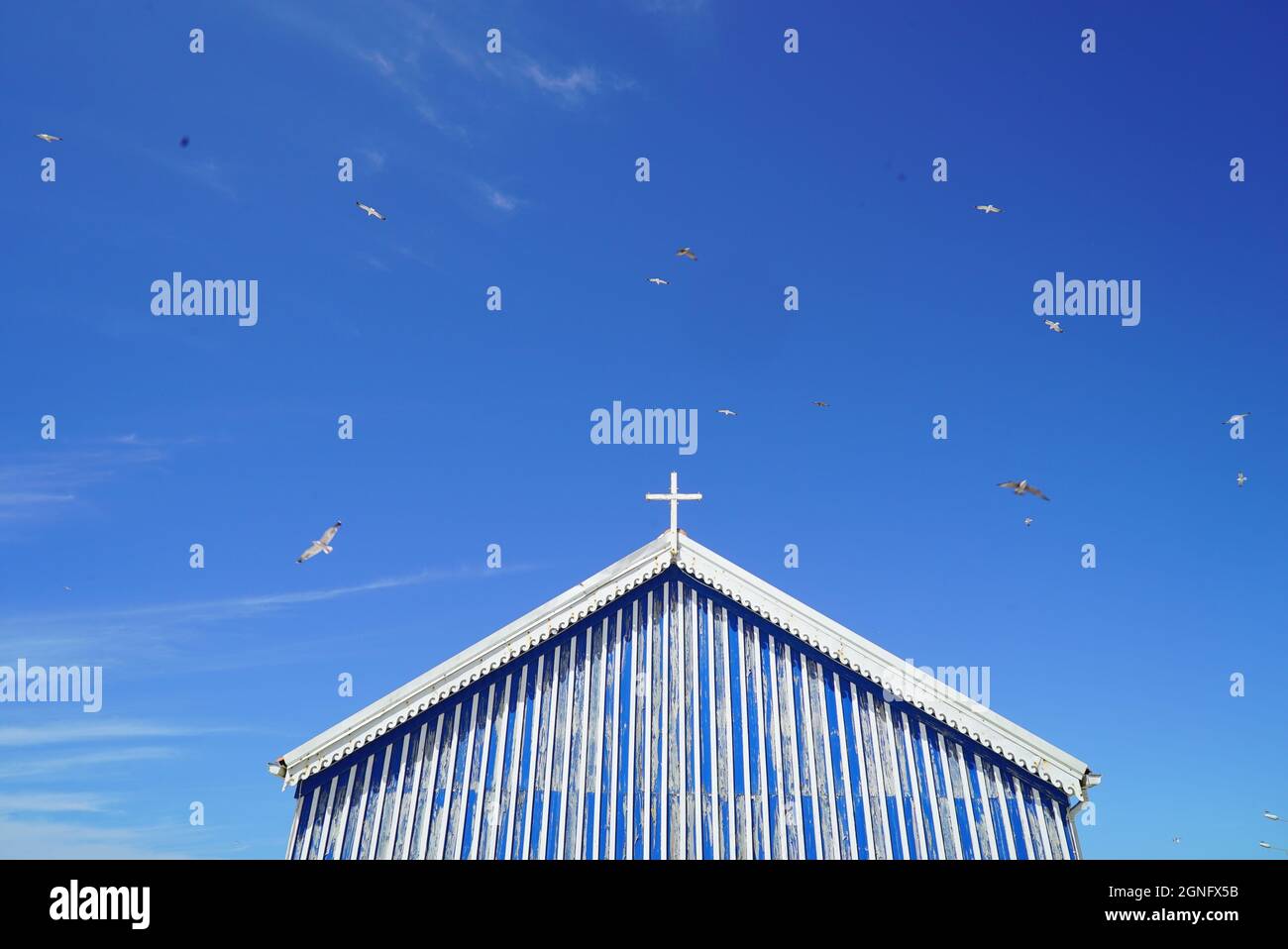 Vista panoramica di un vecchio edificio della chiesa con uccelli che volano sullo sfondo Foto Stock