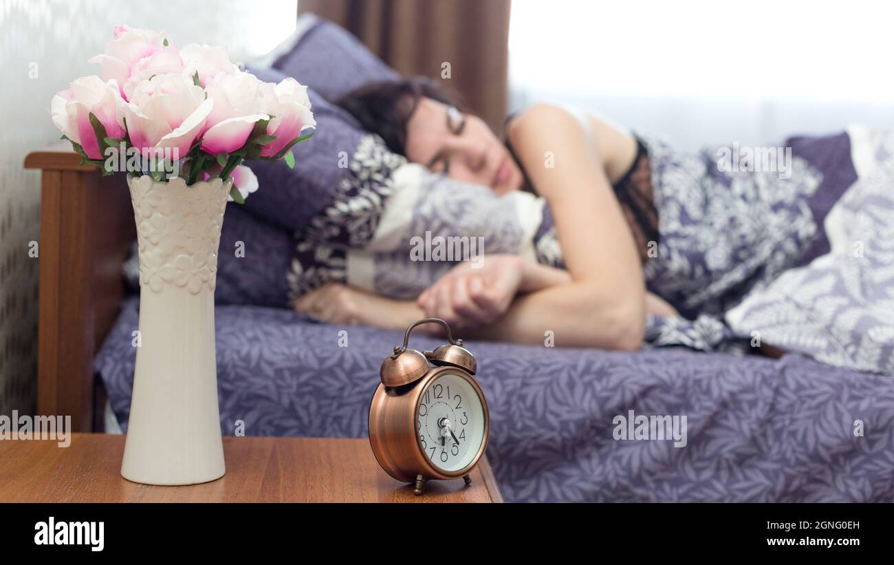 il suono di una sveglia forte non può svegliare una donna che è addormentato veloce. Foto Stock