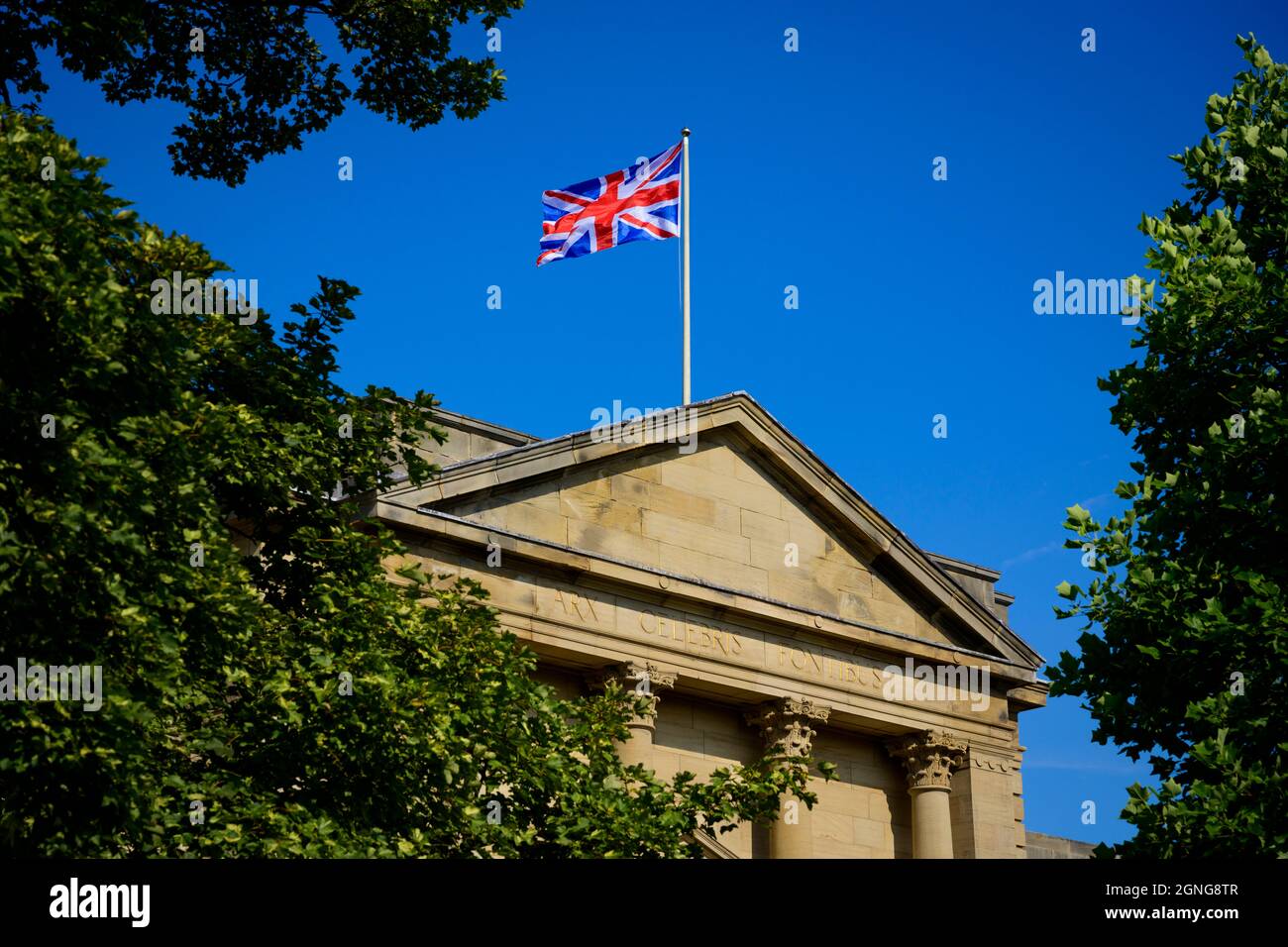 Bandiera Union Jack che sorvola gli uffici del consiglio di Harrogate (motto latino, esterno dell'edificio, cielo blu profondo) - Crescent Gardens, Yorkshire Inghilterra, Regno Unito Foto Stock