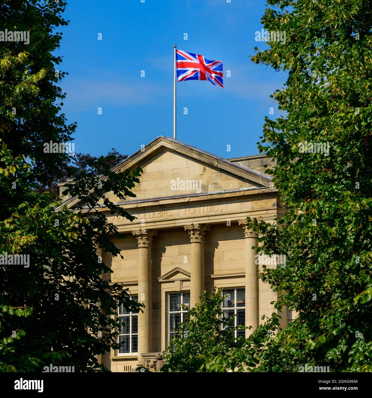 Bandiera Union Jack che sorvola gli uffici del consiglio di Harrogate (motto latino, esterno dell'edificio, cielo blu profondo) - Crescent Gardens, Yorkshire Inghilterra, Regno Unito Foto Stock