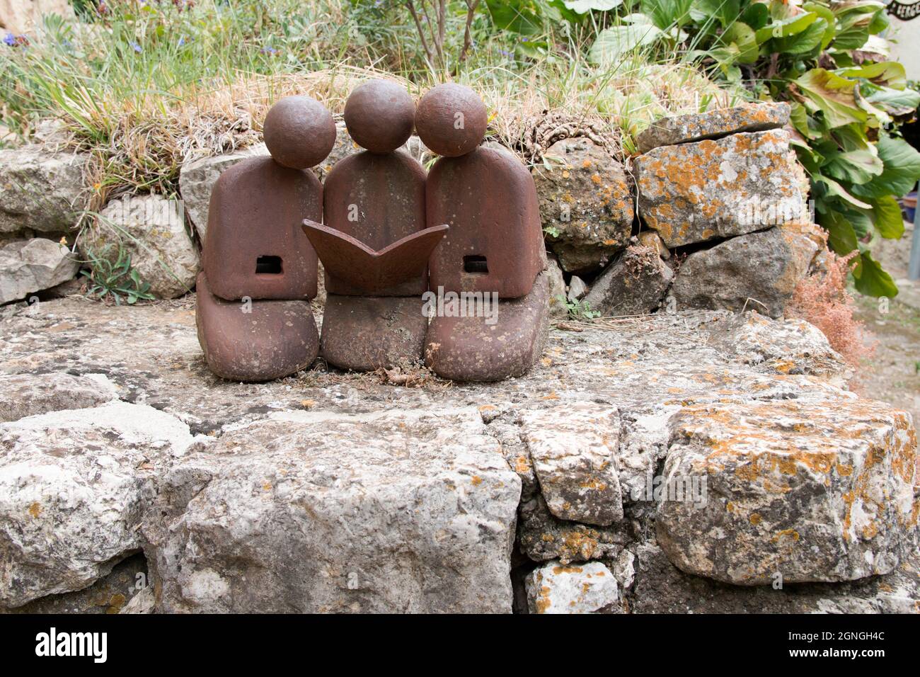 Persone che leggono una statua del libro. I vecchi strumenti e i pezzi di ferro sono un'ispirazione per lo scultore Jean-Pierre Augier, che li riunisce e li trasforma in personaggi. Foto Stock