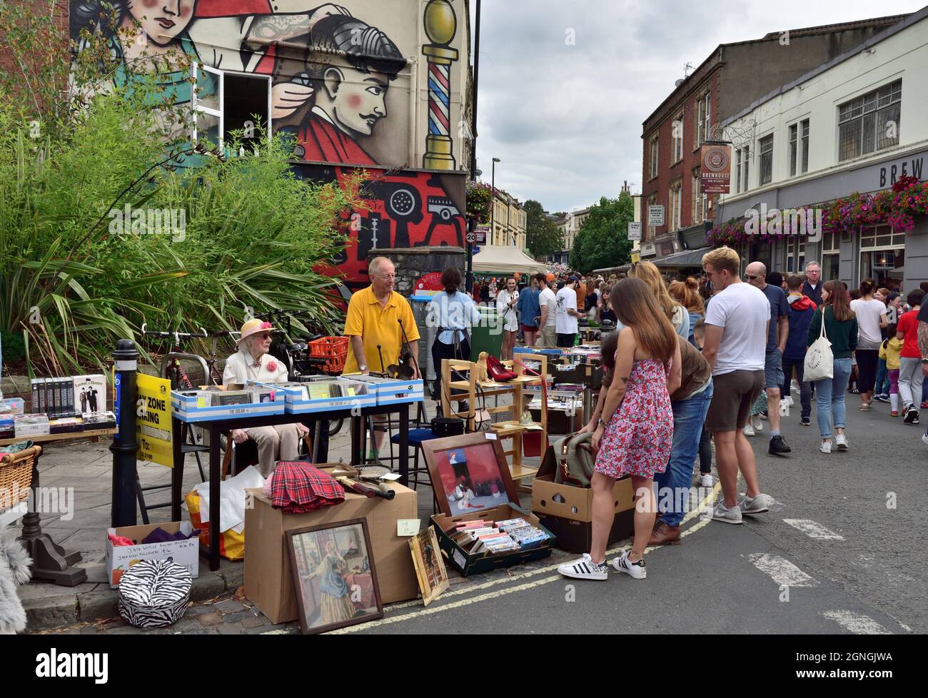 Festa di strada estiva, strada pedonale con mattone-a-brack stalla di fronte al mural di strada, Regno Unito Foto Stock