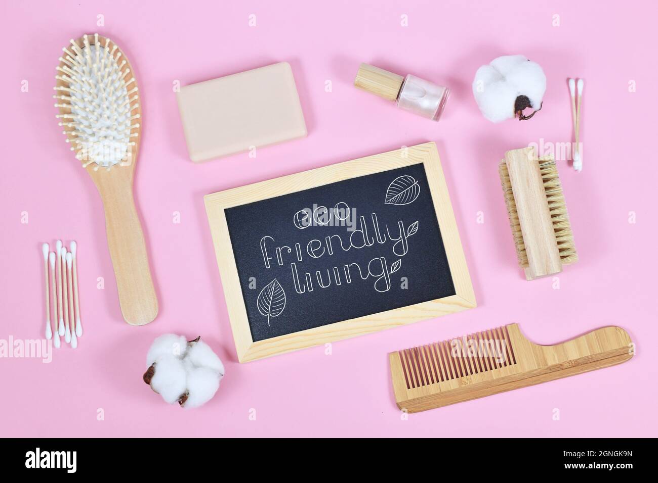 Concetto per vivere ecocompatibile con prodotti di bellezza e igiene in legno come pettine e sapone su sfondo rosa Foto Stock