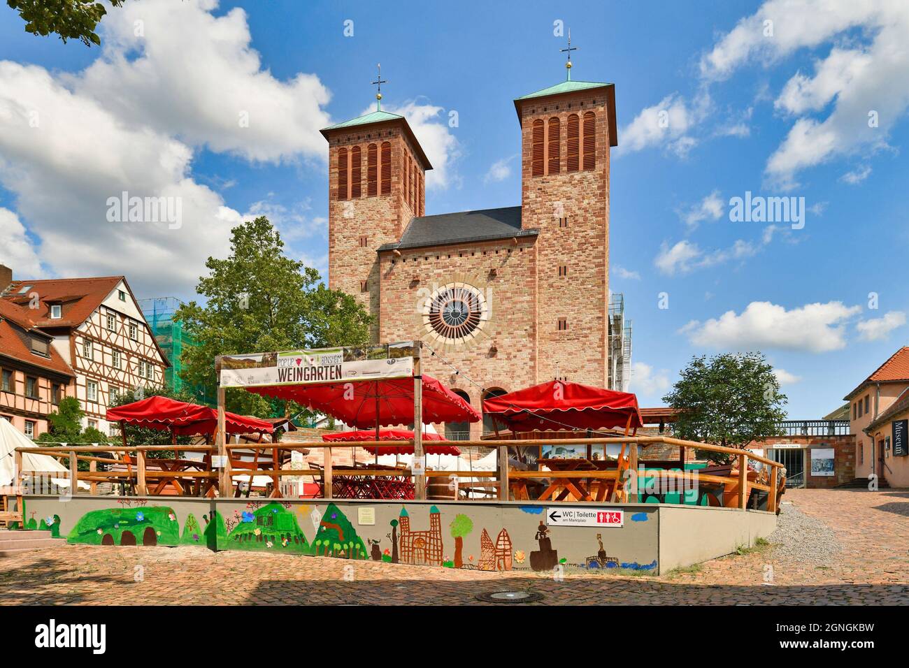 Bensheim, Germania - Agosto 2021: Chiesa Parrocchiale di San Giorgio con ristorante pop-up temporaneo nel centro storico della città nella soleggiata giornata estiva Foto Stock