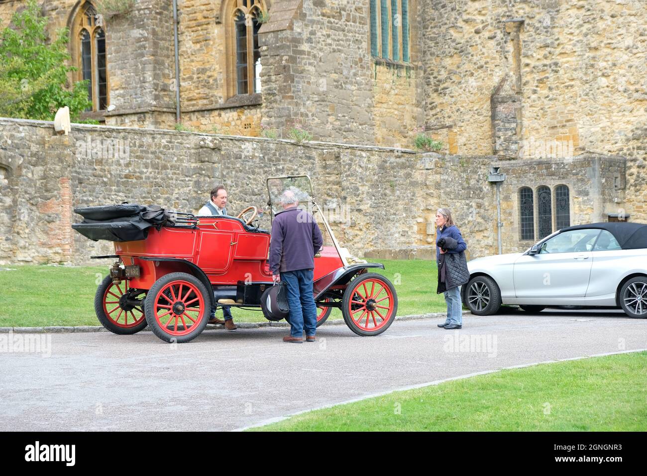 Sherborne, UK - Settembre 2021: Due uomini caucasici adulti che parlano di una Ford Model T rossa, fuori Sherborne Abbey Foto Stock