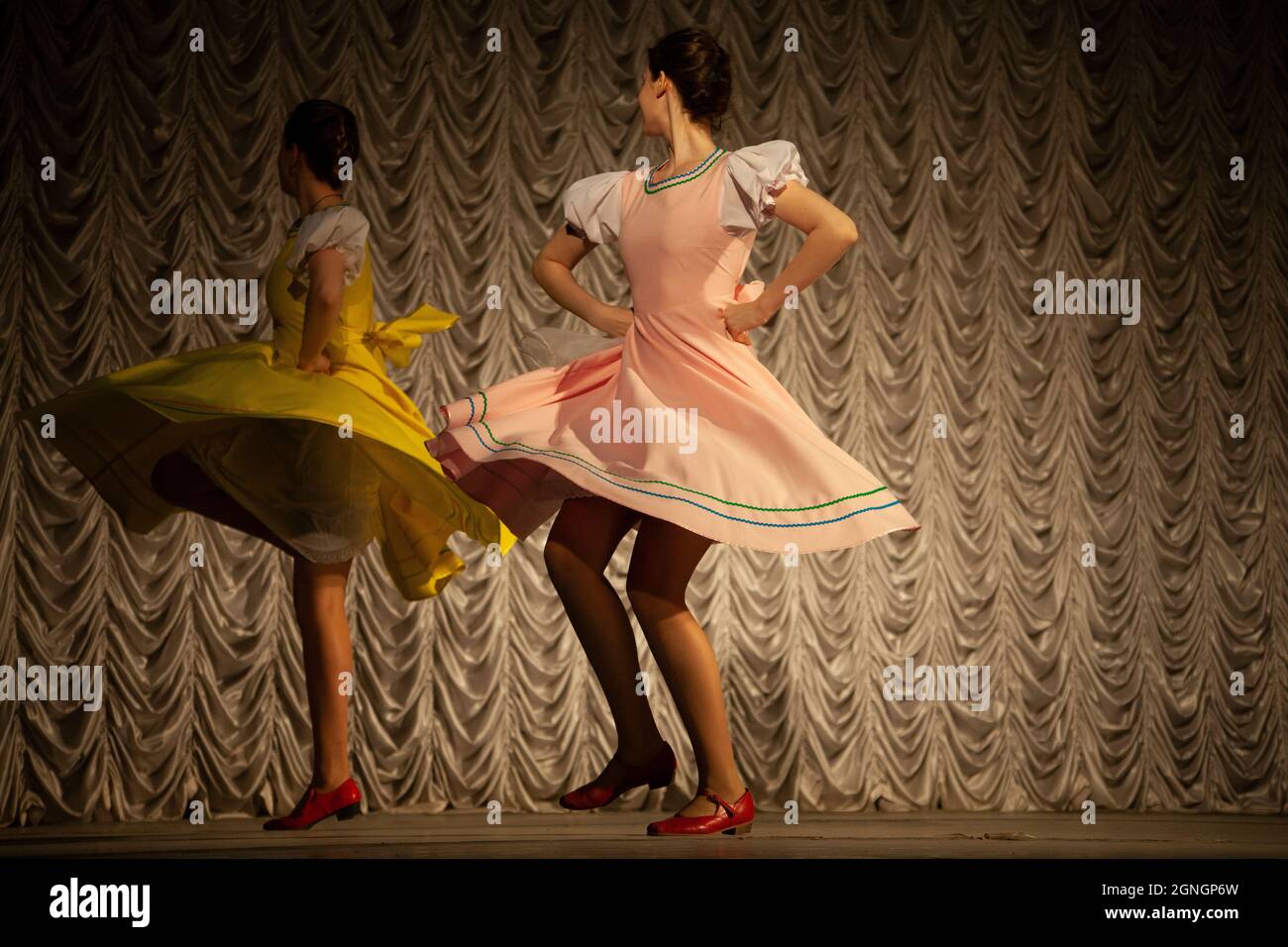 Le ragazze ballano. Le ragazze russe ballano sul palco. Lezione di danza in abiti lunghi. Il movimento strambante del ballerino. Foto Stock