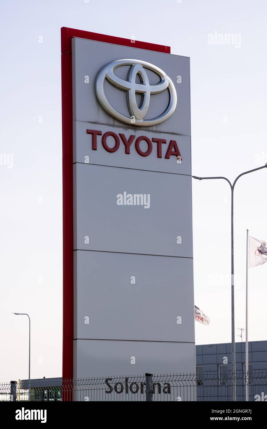 Toyota auto dealer punto. Grande scheda pubblicitaria con logo Toyota e bandiere dietro di esso Foto Stock