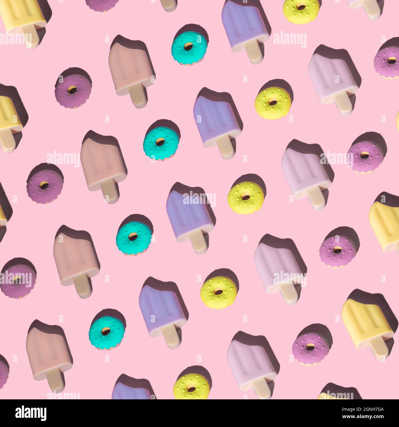 Vista dall'alto layout creativo composto da ciambelle colorate in gomma e gelati su sfondo rosa pastello alla moda. Cibo giocattolo per bambini. Concetto estivo minimo. Foto Stock