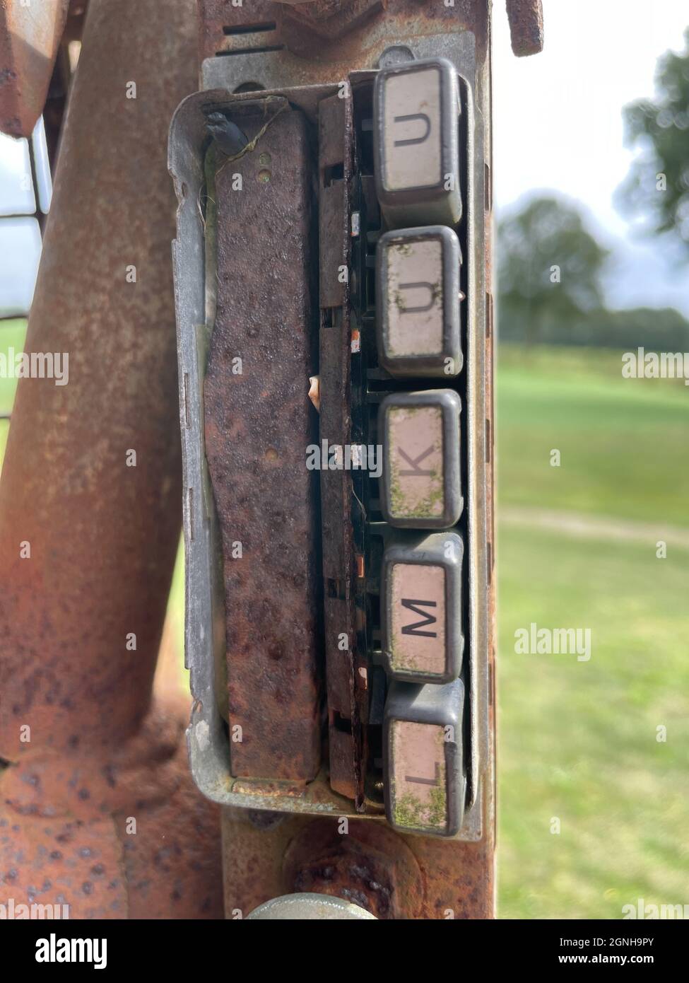 Scatto verticale di lettere metalliche arrugginite su un vecchio palo del telefono Foto Stock