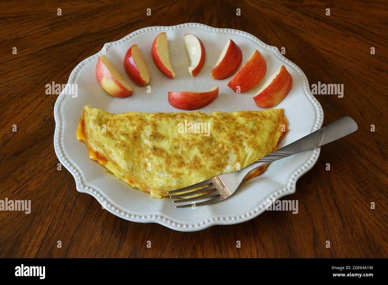 Una frittata di formaggio e fette di mela su un piatto Foto Stock