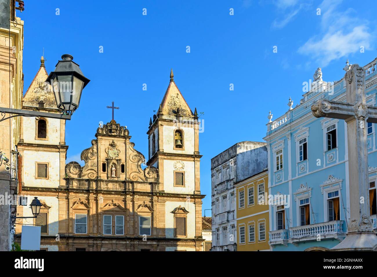 Facciata di una vecchia chiesa storica e case colorate in stile coloniale nella piazza centrale del quartiere Pelourinho nella città di Salvador, Bahia Foto Stock