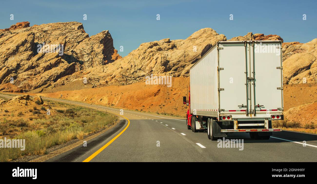 Veicolo semi-camion moderno sulla Scenic Utah Highway. Formazioni rocciose Paesaggio. Tema dell'industria dei trasporti americana. Foto Stock