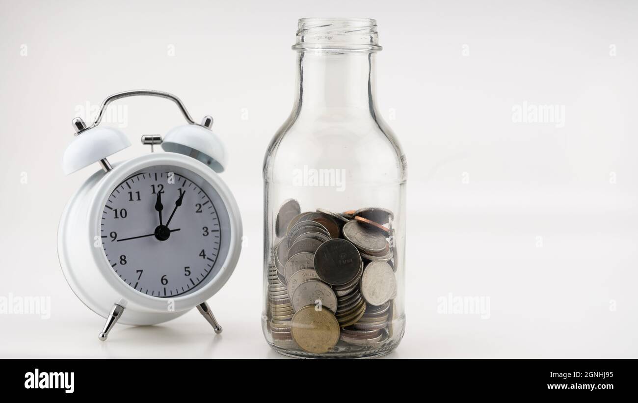 Concetto Business finanza e Shopping vendita monete in vaso con sveglia bianca Business oggetti isolati su sfondo bianco Foto Stock