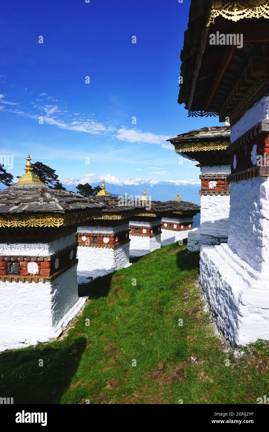 Guardando giù una fila tra alcuni dei 108 Chortens Druk Wangyal identici che si trova al Passo Dochula del Bhutan sulla strada da Thimphu a Punakha. Foto Stock
