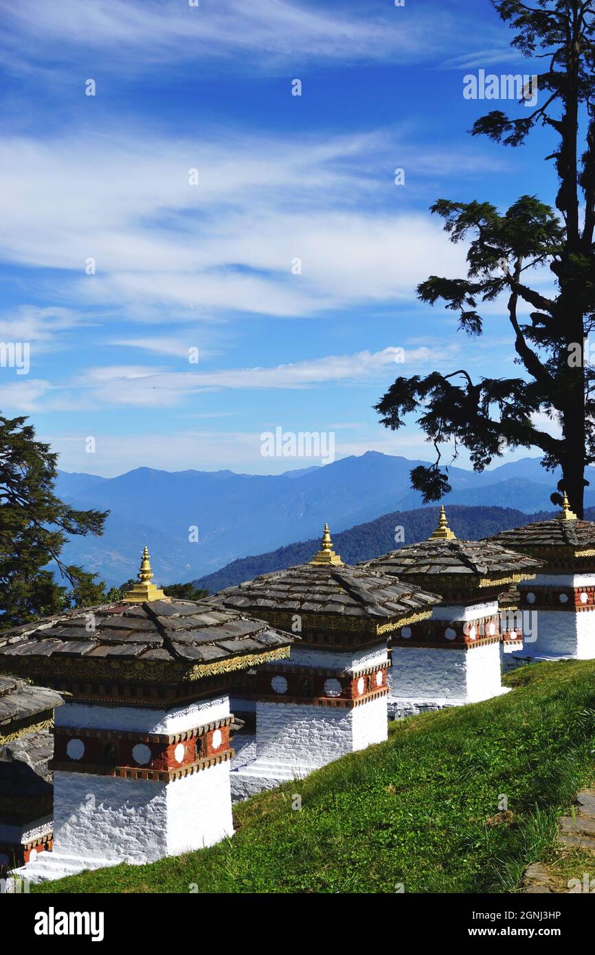 Vista di alcuni dei Chortens Druk Wangyal al Passo Dochula di Bhutan, tra Thimphu e Punakha, con le montagne innevate di Himalaya oltre Foto Stock