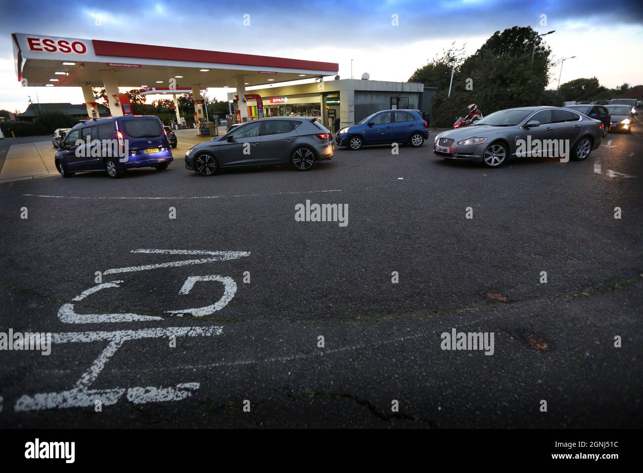 Peterborough, Regno Unito. 25 Settembre 2021. I clienti fanno la fila per il carburante presso un distributore di benzina esso, vicino Peterborough.A carenza di conducenti di veicoli pesanti (HGV) ha ridotto la quantità di carburante nelle previsioni del garage. Esso limita i clienti a £ 30.00 di carburante fino a quando la consegna non ritorna alla normalità. Credit: SOPA Images Limited/Alamy Live News Foto Stock