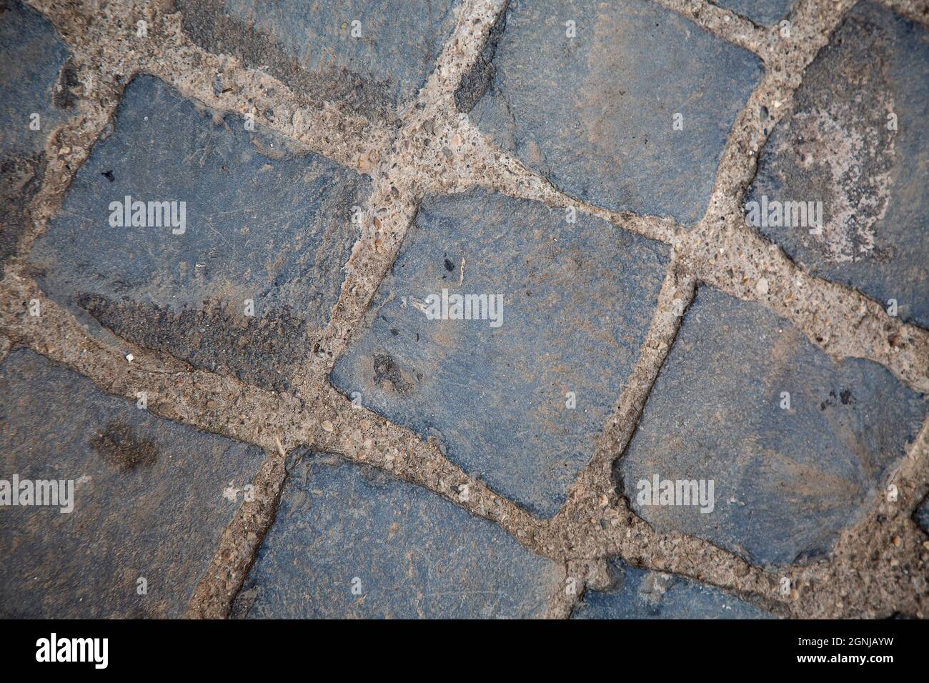 vista dall'alto su un pavimento di ciottoli quadrato grigio. Composizione geometrica diagonale. Superficie stradale. Carta da parati e sfondo. italiano tradizionale Foto Stock