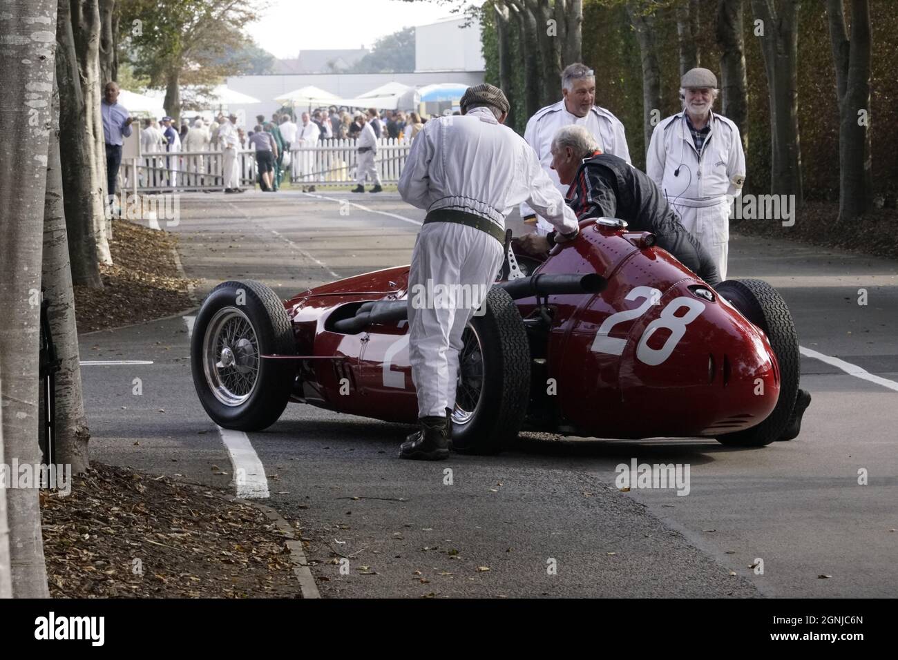 Una Maserati 250F viene spinta indietro al paddock dopo le qualifiche, al Goodwood Revival Foto Stock