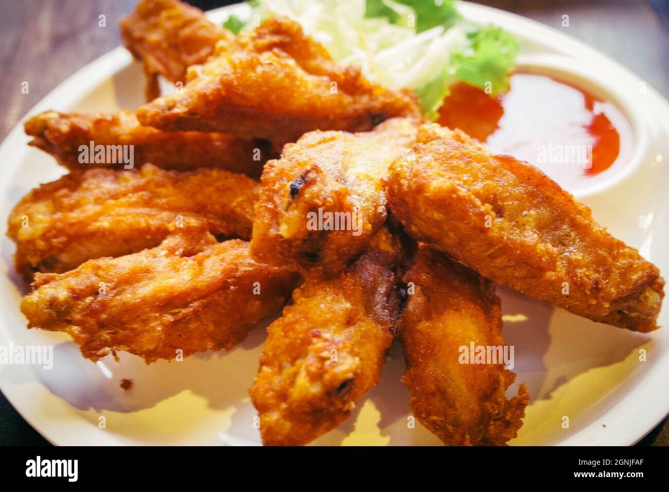 Thai food piatto di ali di pollo fritte con insalata e salsa dolce. Foto Stock