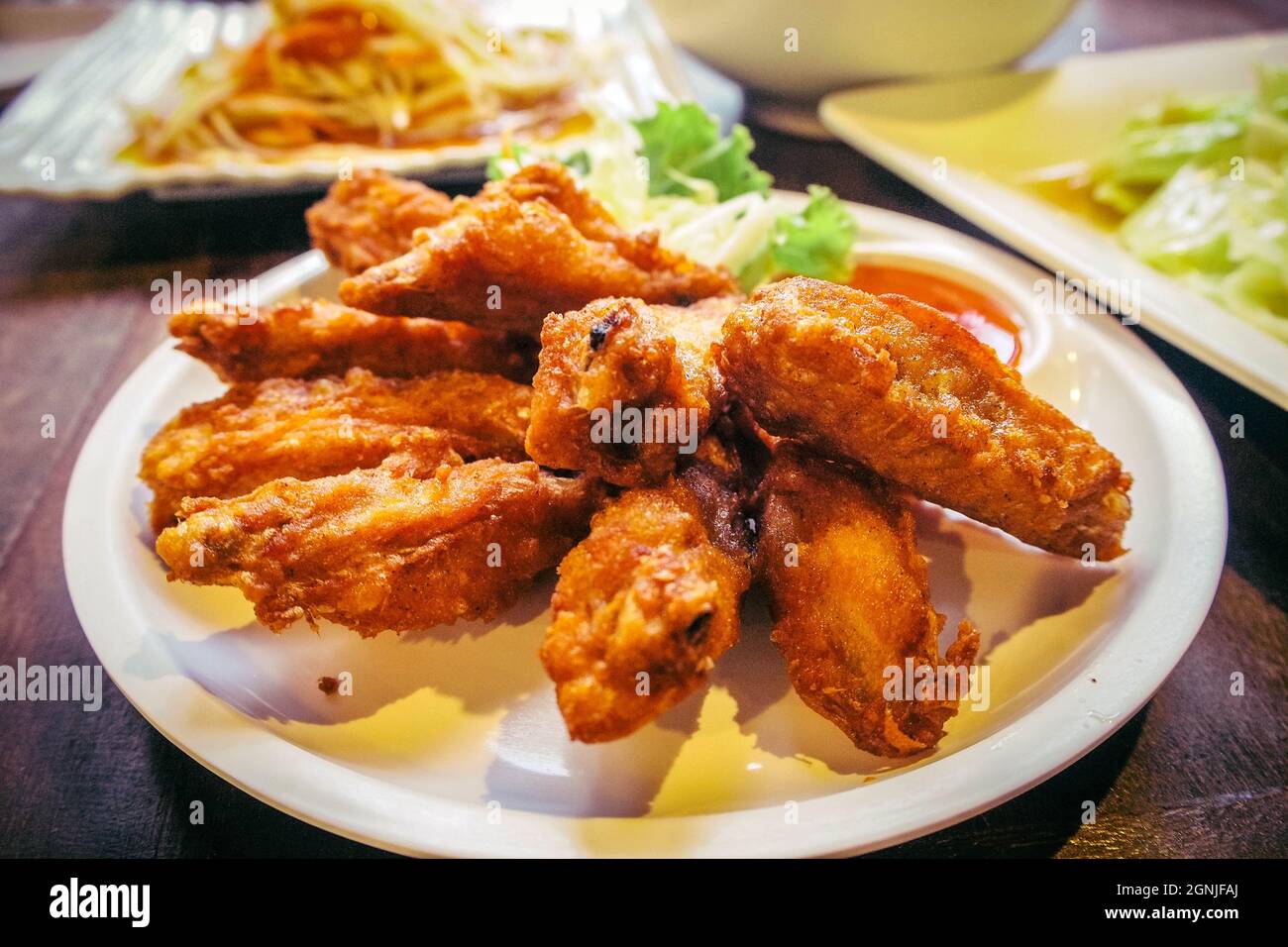Thai food piatto di ali di pollo fritte con insalata e salsa dolce. Foto Stock
