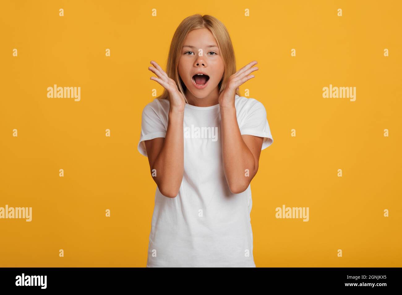 Spaventata sorpresa sorpresa scioccata ragazza europea adolescente in t-shirt bianca urlando a bocca aperta Foto Stock