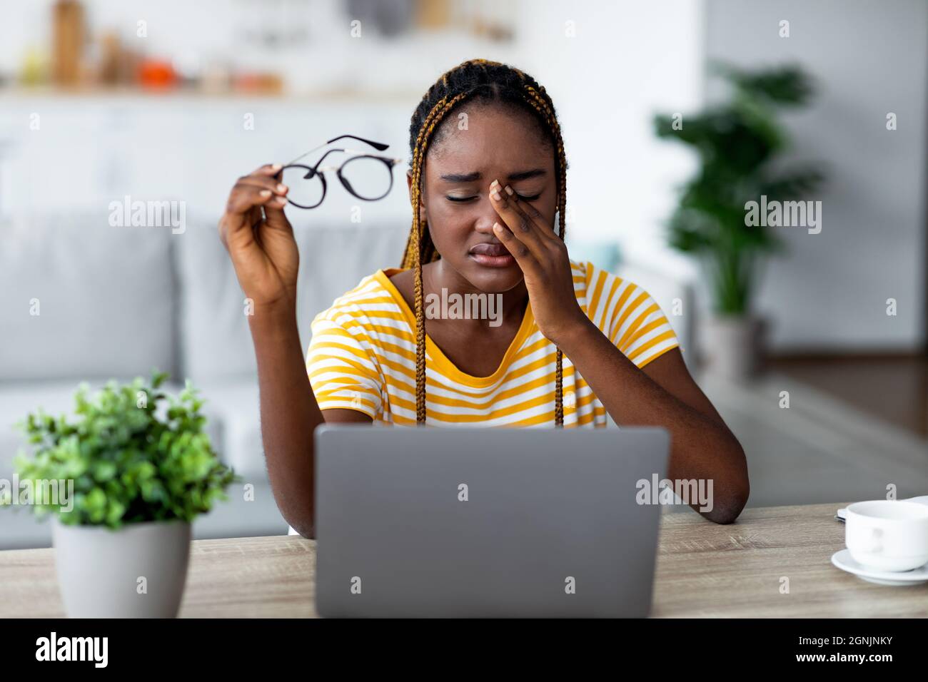 Donna nera sconvolto seduta davanti al laptop e piangere Foto Stock