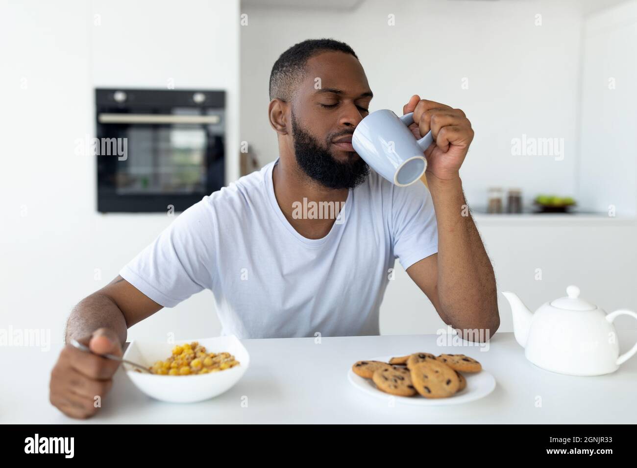 Uomo nero che soffre di insonnia bere caffè Foto Stock