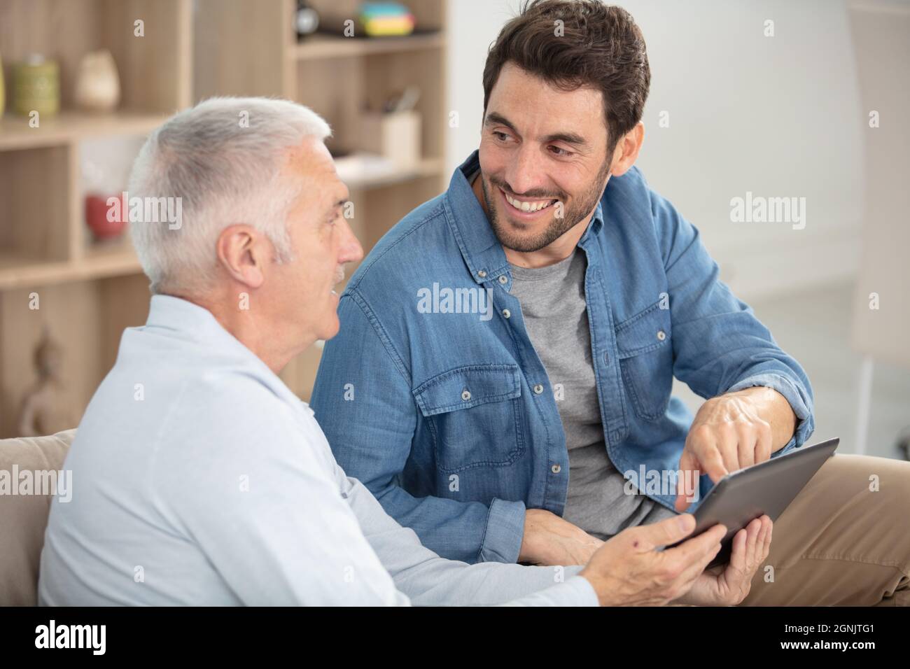 padre anziano con figlio adulto che parla di finanza Foto Stock