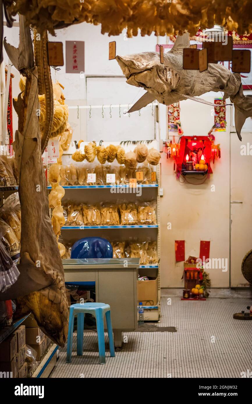 Squali interi appesi in un negozio che vende prodotti di pesce essiccato a Tai o, Isola di Lantau, Hong Kong Foto Stock