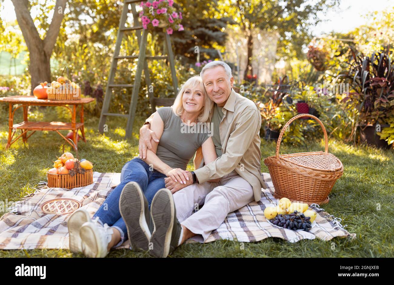 Felice coppia anziana riposo nel parco autunnale, avendo pic-nic e sorridendo a macchina fotografica, spazio copia Foto Stock