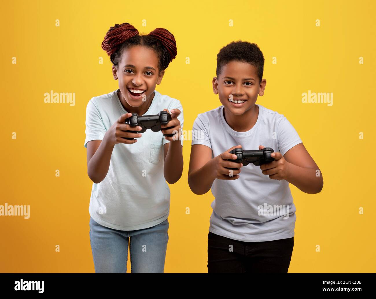 Gioioso fratello nero e sorella che tiene i joystick Foto Stock