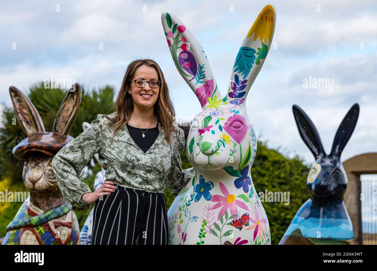 North Berwick, East Lothian, Scozia, Regno Unito, 26 settembre 2021. Hare Art Trail: 10 gigantesche sculture di lepre dipinte a mano, ognuna di un artista diverso, sono riunite nel prato del Marine Hotel prima che l'asta di beneficenza si svolgersi il 1 ottobre. E 'organizzato dalla carità di tregua Leuchie House in collaborazione con Wild in Art. Raffigurato: Artista Rosie Watson con la sua scultura di lepre dipinta Foto Stock