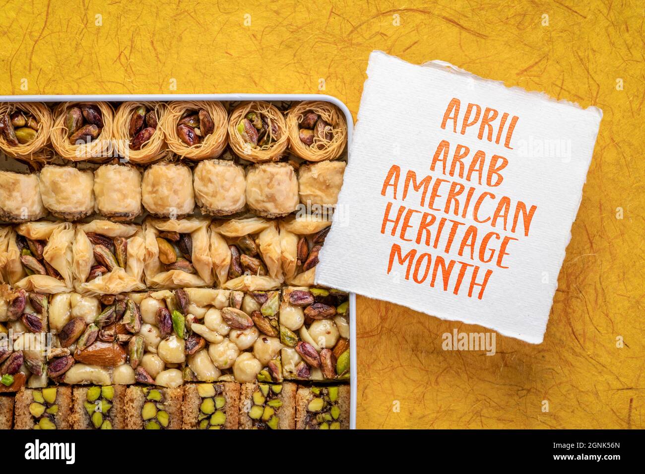 Aprile - Arab American Heritage Month, nota di promemoria con una scatola in scatola di tradizionale pasticceria turca di baklava Foto Stock