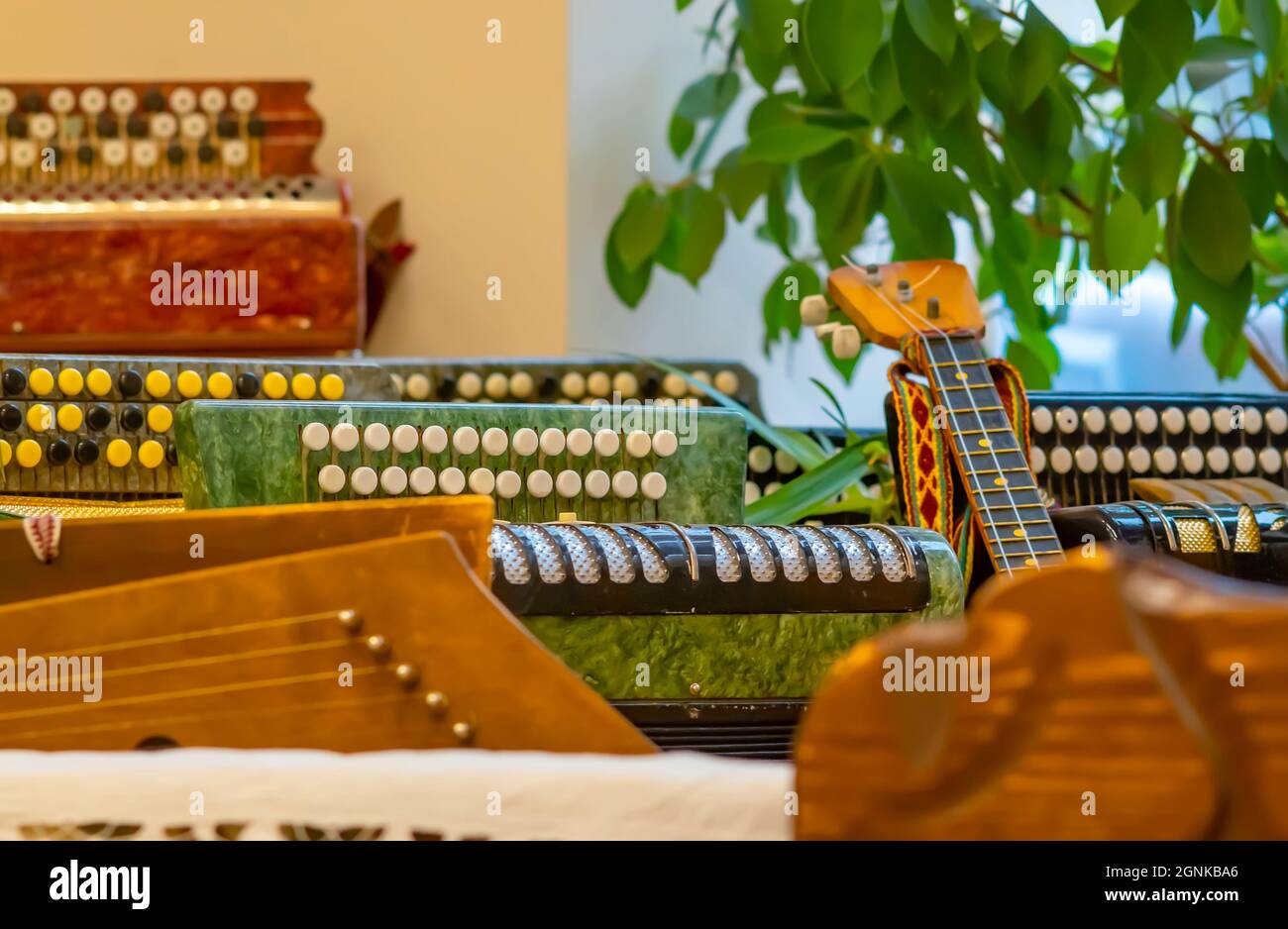 Molti, un set di strumenti musicali popolari russi, armonie, fisarmonica, chitarra, balalaika si trovano nella stanza vicino alla finestra Foto Stock