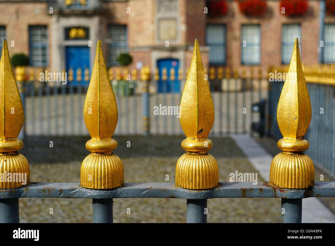 Primo piano della recinzione color oro nella piazza della città nel centro storico di Düsseldorf, scintillante al sole del tardo pomeriggio. Foto Stock