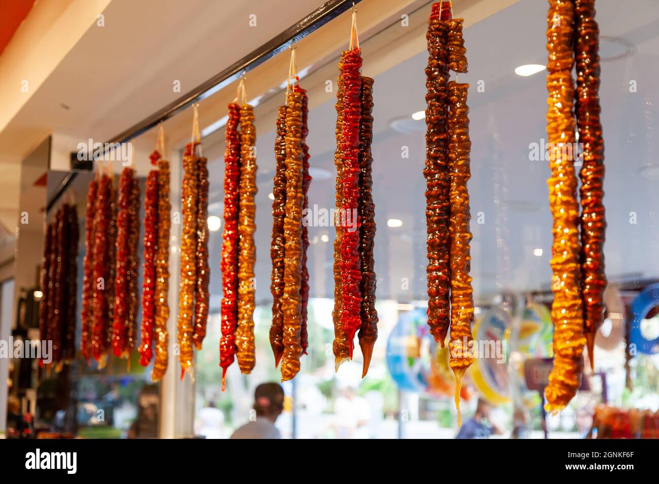 Una bella, appesa, multicolore Churchkhela sul banco del mercato nel Kemer, Turchia. Dolce tradizionale turco fatto in casa. Consiste di var Foto Stock