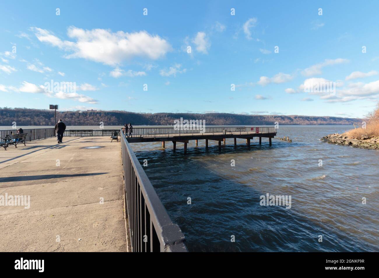 Il molo Dyckman sul lato Manhattan del fiume Hudson in una giornata fredda e ventosa con alcune persone che camminano intorno Foto Stock