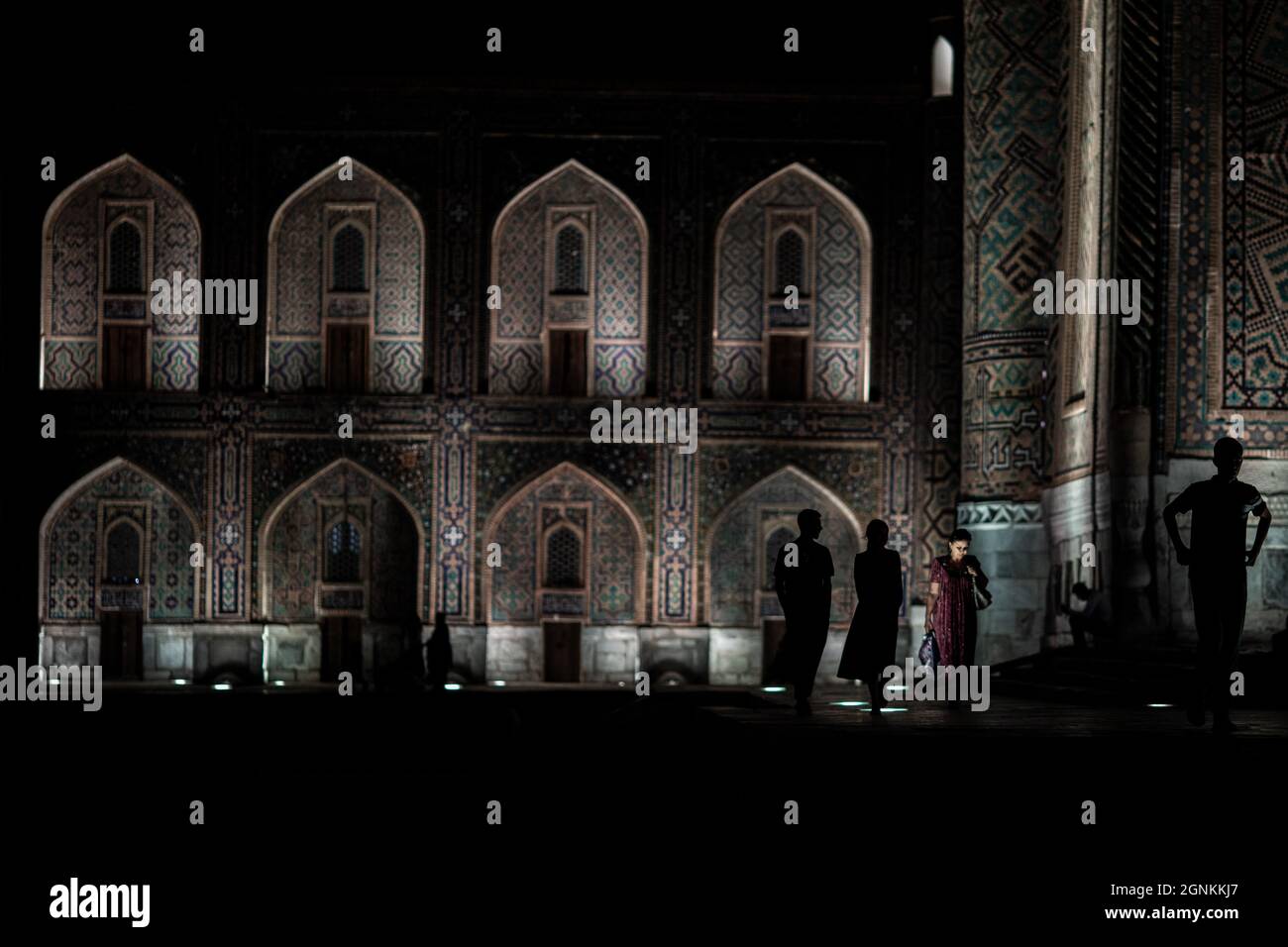 26 settembre 2021, Uzbekistan, Samarcanda: Gli Uzbekistan camminano presso il punto di riferimento storico del Registan a Samarcanda. Il Registan era una piazza pubblica e un centro dell'antica Samarcanda durante l'Impero Timuride, usato per proclami reali, annunciati da blasti su enormi tubi di rame ed esecuzioni pubbliche. Foto: Oliver Weiken/dpa Foto Stock